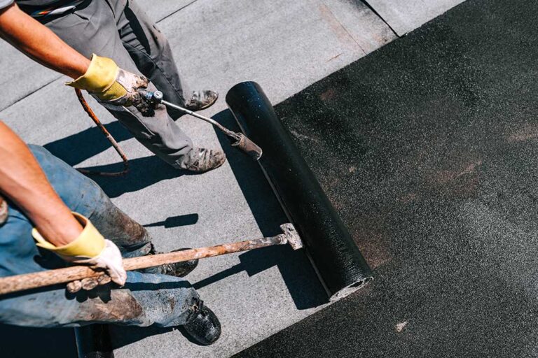 Roof workers inspect modern shingles, attic ventilation, solar roofing components, and moisture sensors on a residential roof.